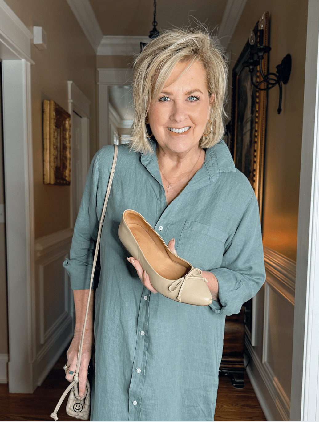 Tania Stephens wearing Frank & Eileen green linen dress and holding ballet flats